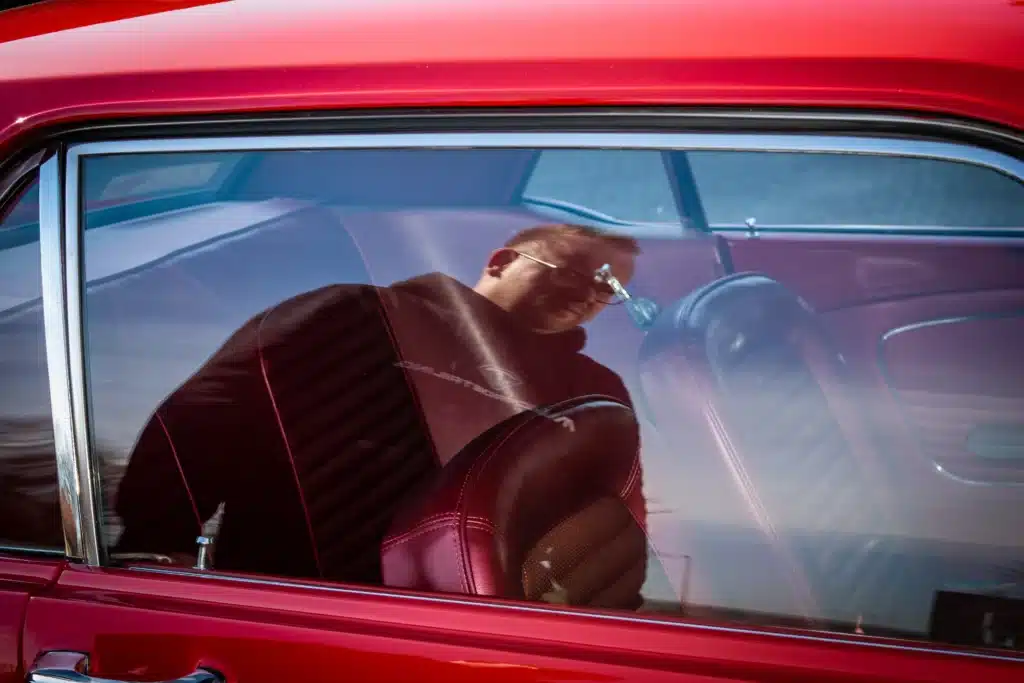 Detailer reinigt voorruit van rode auto tijdens exterieurreiniging in Heerhugowaard