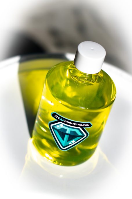 Fles met gele vloeistof en een logo in de vorm van een diamant.